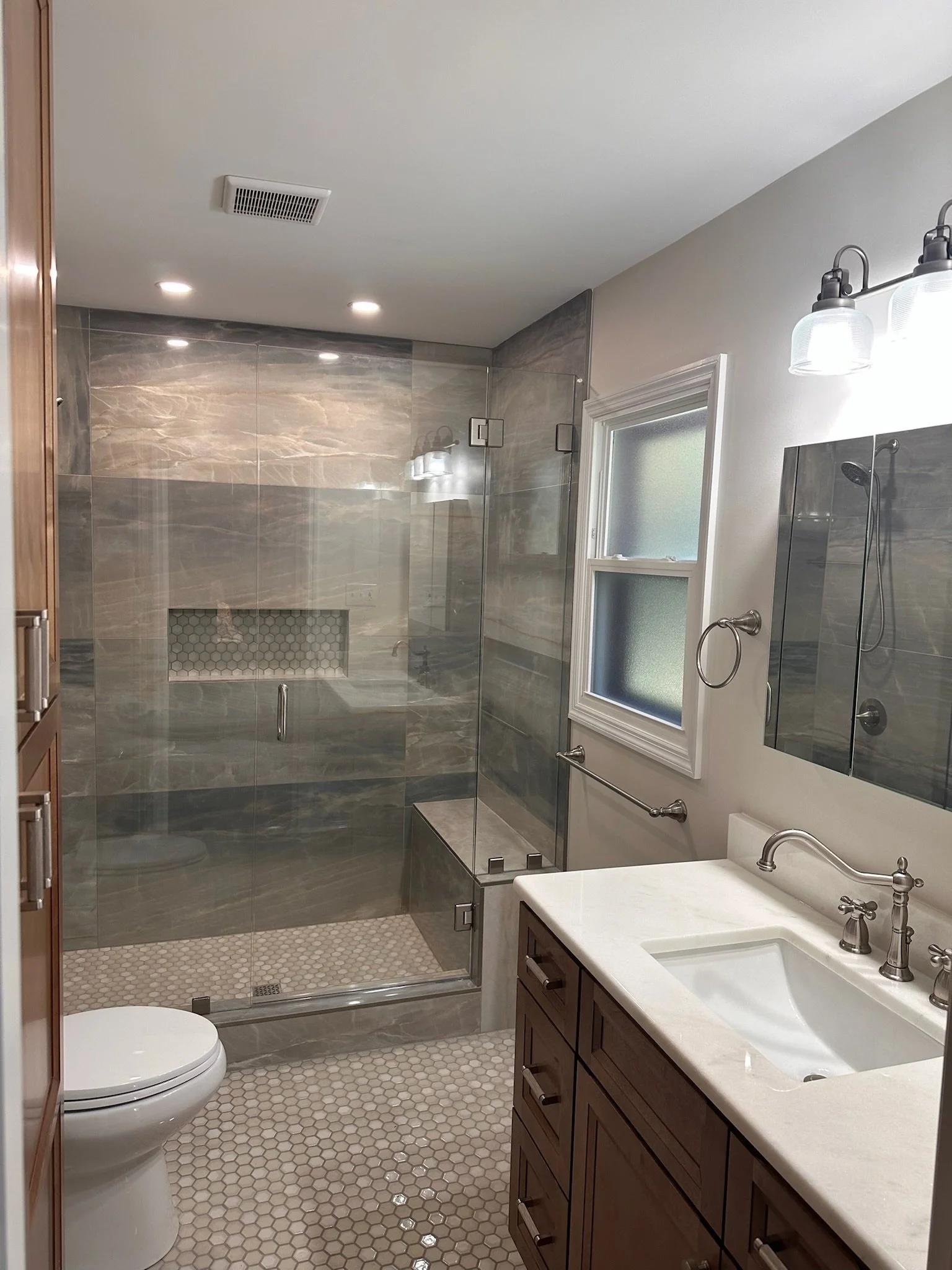 Tiled walk-in shower with glass enclosure