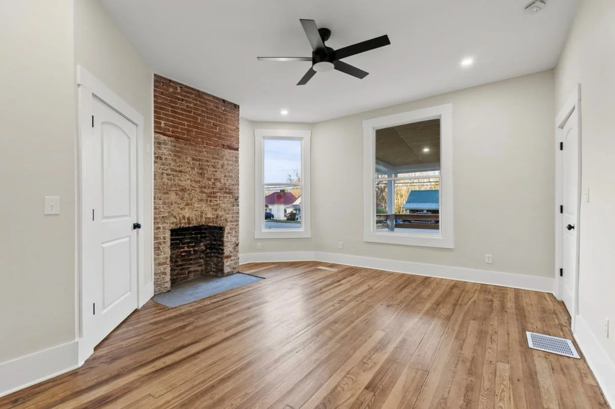 Bedroom with brick fireplace and refinished floors