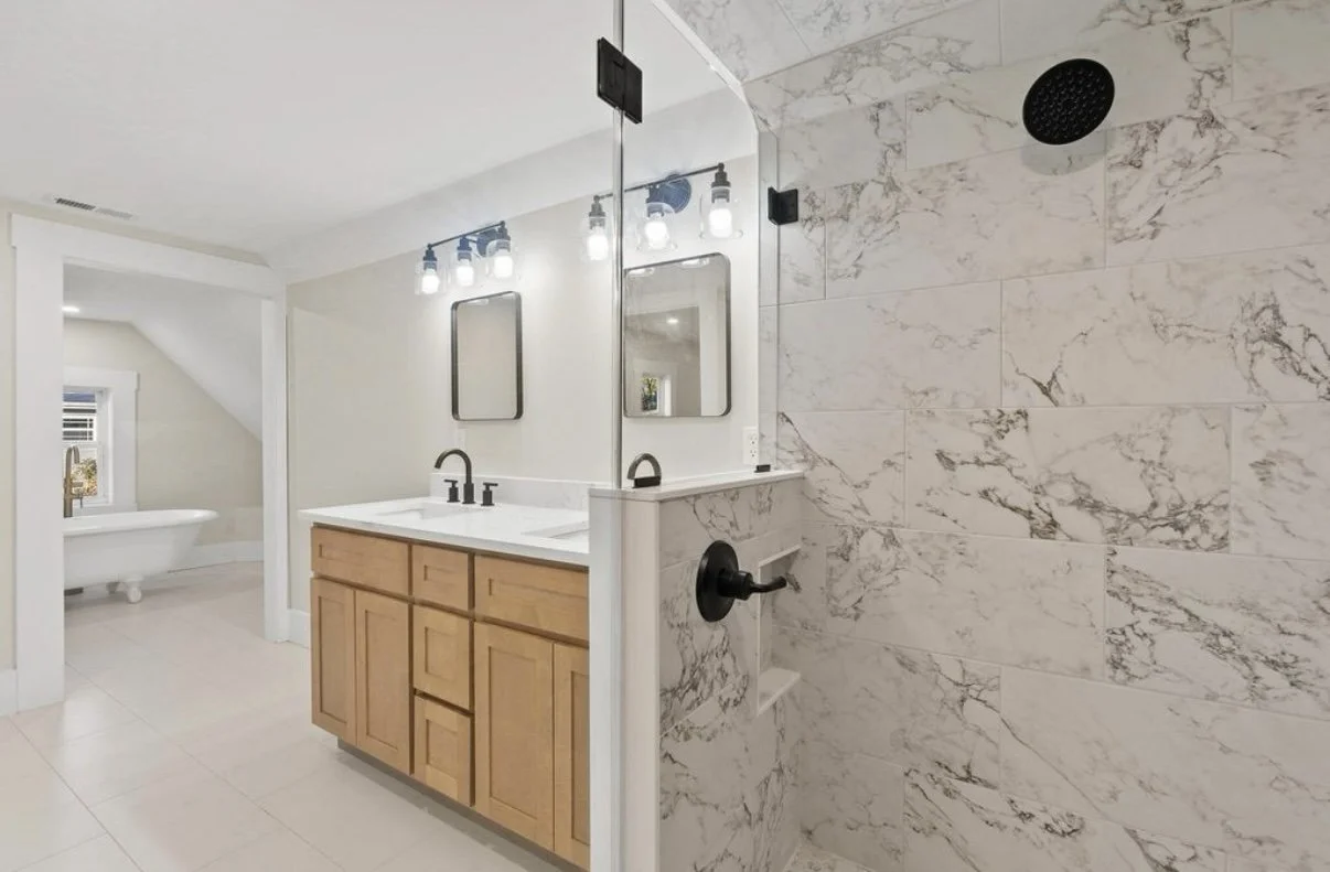 Bathroom with wood vanity and marble-look shower