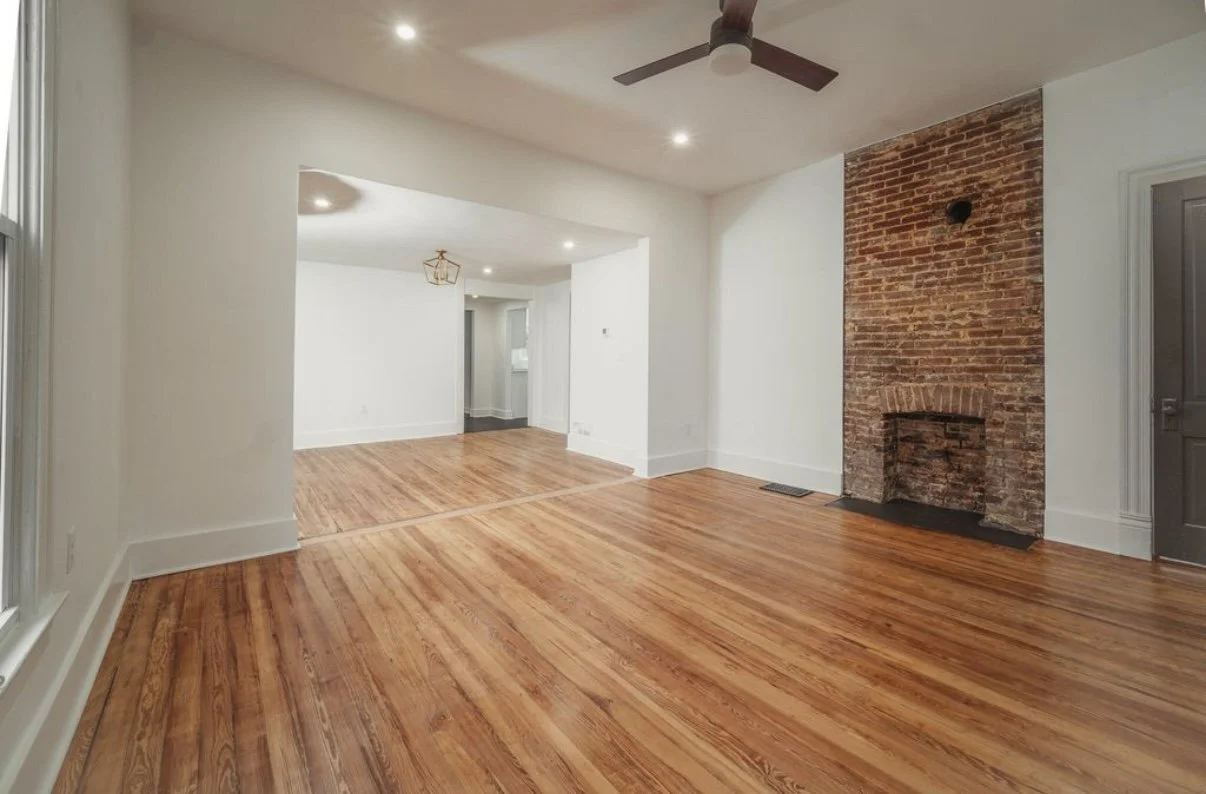 Refinished hardwood floors and exposed brick fireplace