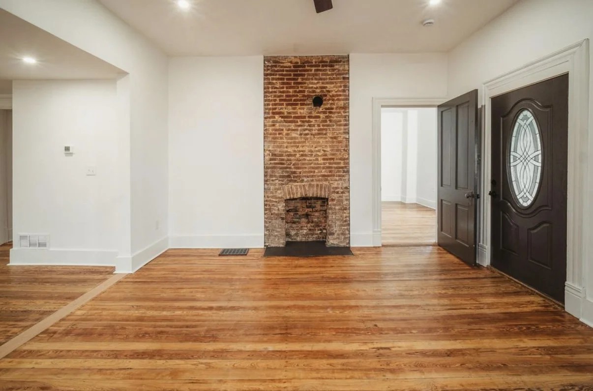 Open living area with brick fireplace and hardwood floors