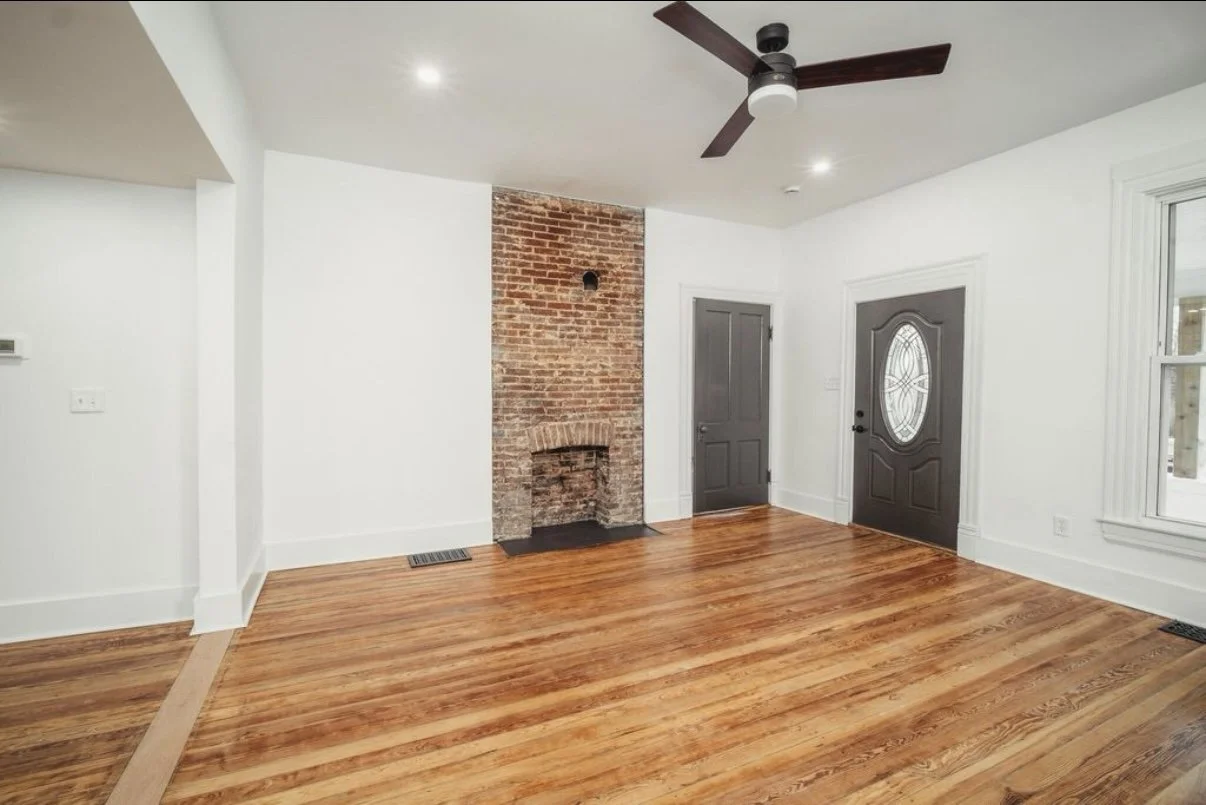 Living room with exposed brick and new front door